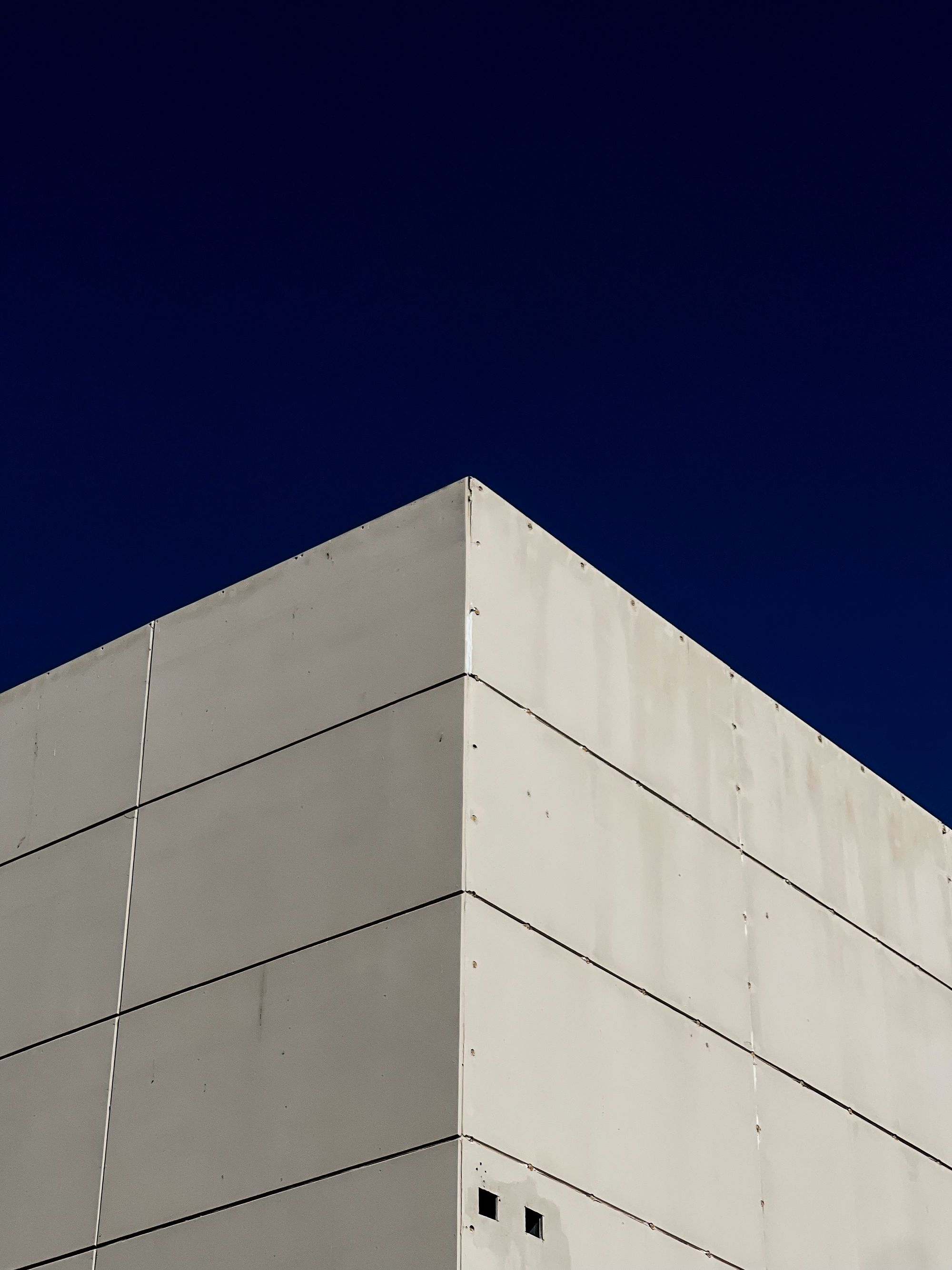 Concrete building against a deep blue sky